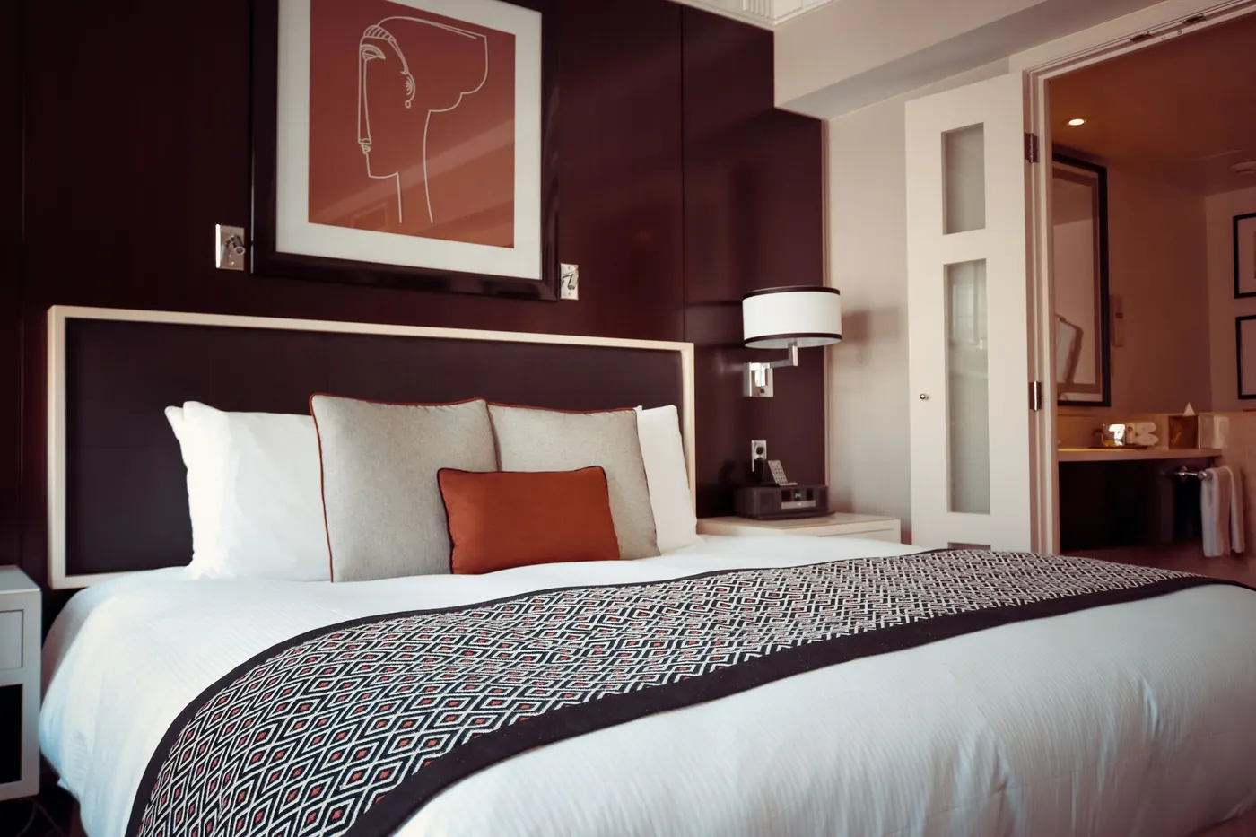 Quarto de hotel com cama arrumada e iluminação suave