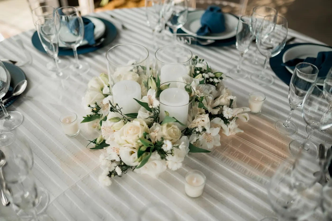 Mesa de casamento com arranjo de flores brancas e velas