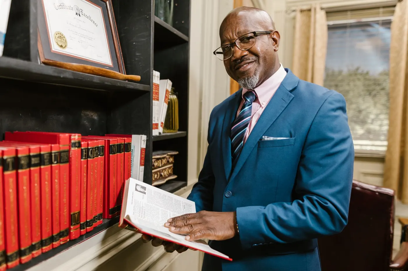 Advogado consultando um livro entre estantes jurídicas