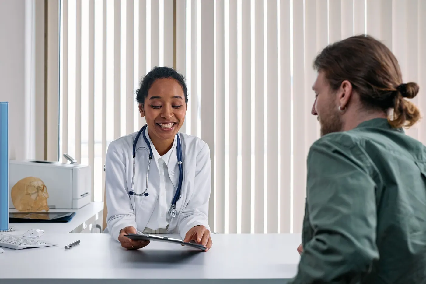 Médica conversando com um paciente no consultório